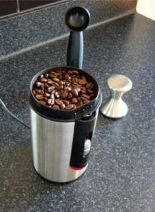 Add coffee beans to grinder.